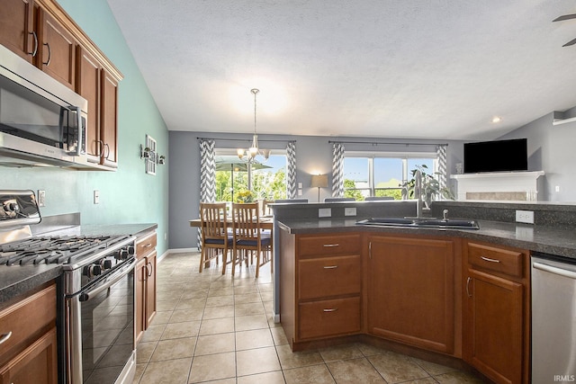 kitchen featuring stainless steel appliances, sink, light tile patterned floors, decorative light fixtures, and an inviting chandelier