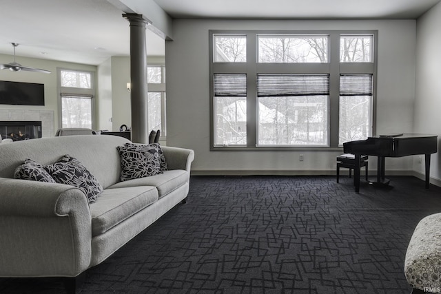 living room featuring a tile fireplace, decorative columns, plenty of natural light, and ceiling fan