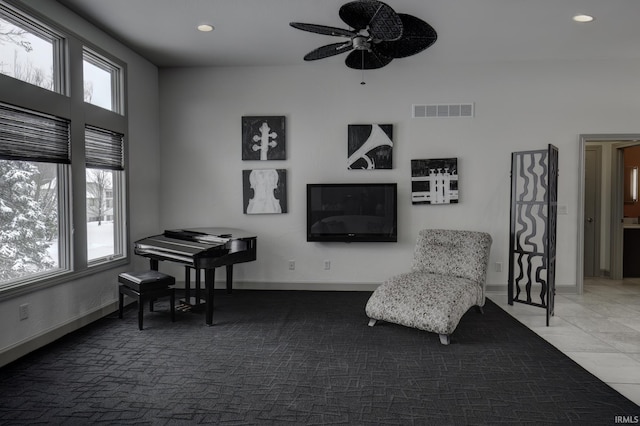 living area with tile patterned floors and ceiling fan