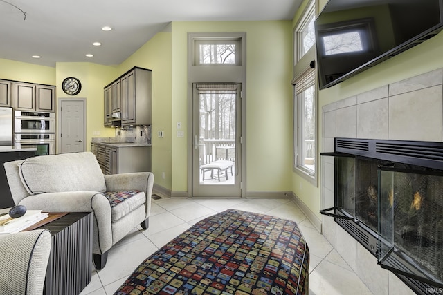 living room with light tile patterned floors and a tile fireplace