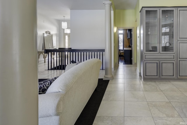 corridor with light tile patterned floors and decorative columns