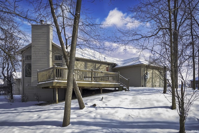 snow covered house with a wooden deck