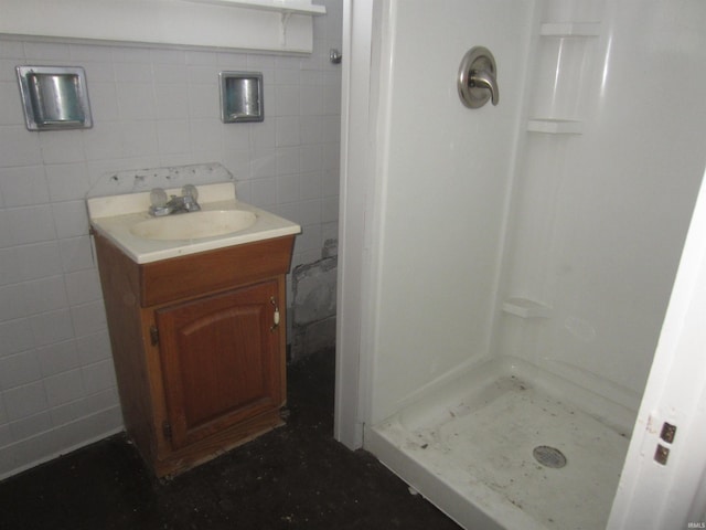 bathroom with vanity, tile walls, and walk in shower