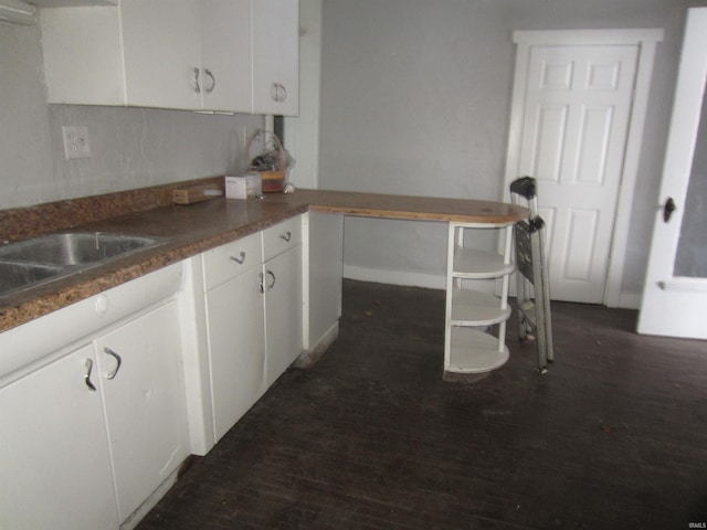 kitchen with white cabinets, decorative backsplash, and dark hardwood / wood-style flooring