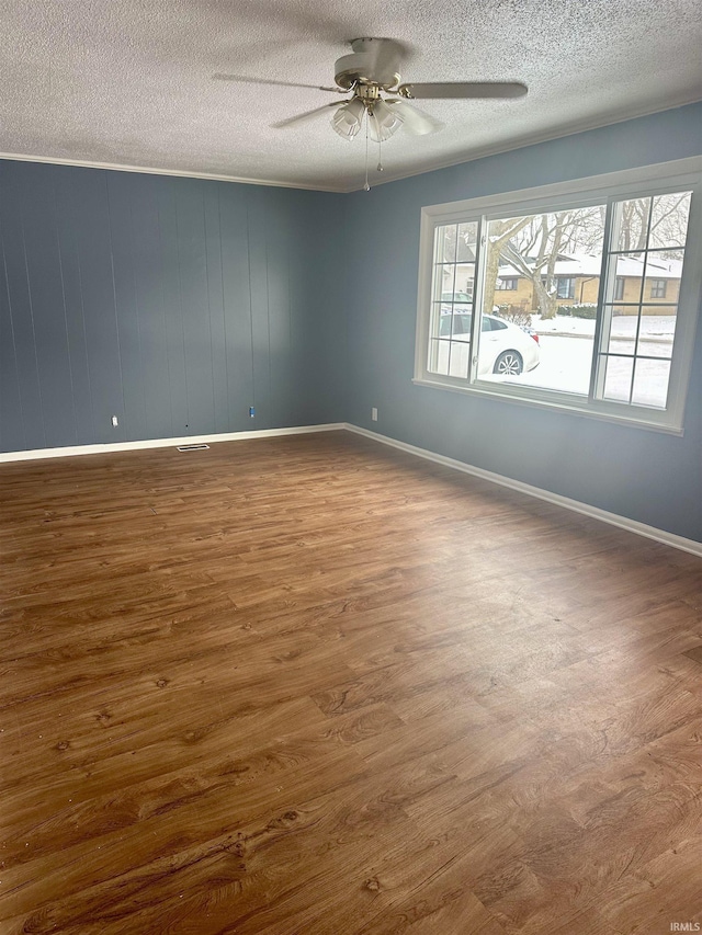 spare room featuring ceiling fan, wood-type flooring, and a textured ceiling