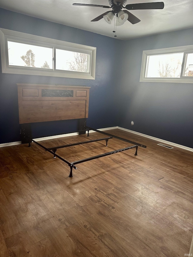 unfurnished bedroom with ceiling fan and hardwood / wood-style flooring