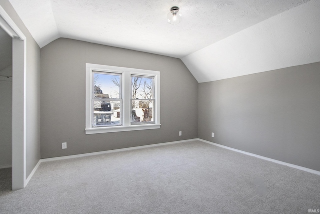 bonus room with carpet flooring, a textured ceiling, and lofted ceiling