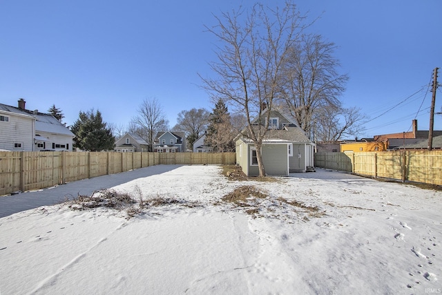 yard layered in snow featuring a storage shed