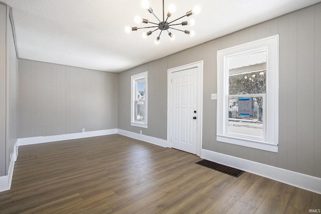 entryway with a notable chandelier and dark hardwood / wood-style floors