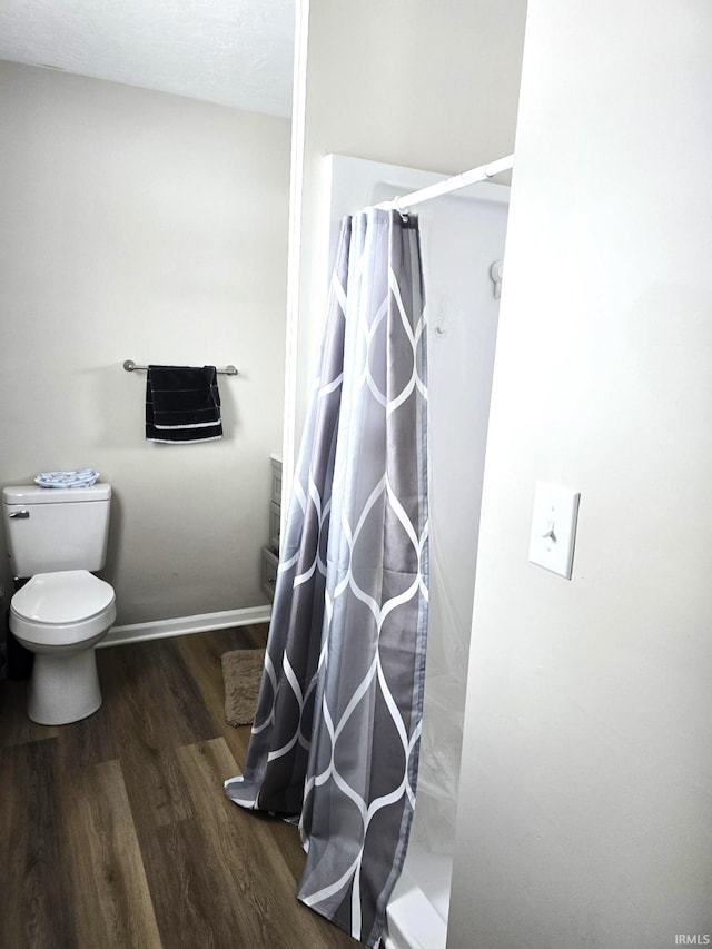 bathroom featuring a shower with shower curtain, toilet, and wood-type flooring