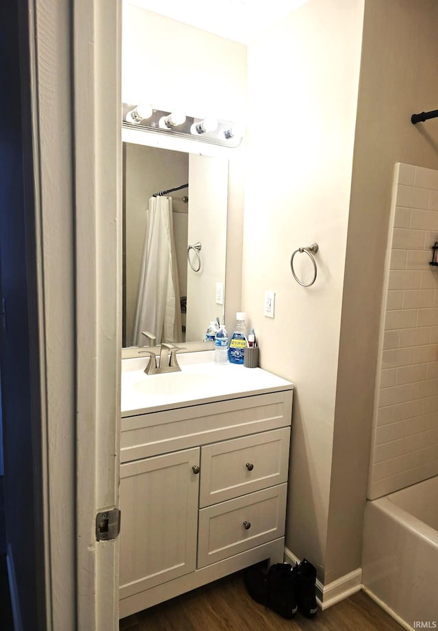 bathroom featuring hardwood / wood-style floors, vanity, and shower / bath combo