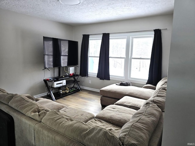 living room featuring a wealth of natural light, light hardwood / wood-style flooring, and a textured ceiling