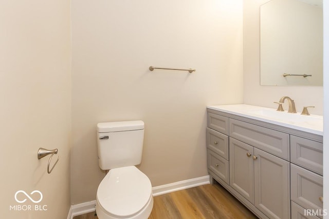 bathroom featuring hardwood / wood-style flooring, vanity, and toilet