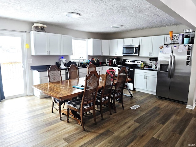 dining room with a textured ceiling and hardwood / wood-style flooring