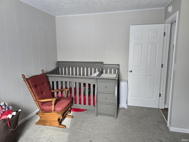 carpeted bedroom with a textured ceiling and a crib