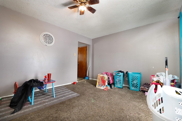 recreation room with carpet flooring, a textured ceiling, and ceiling fan