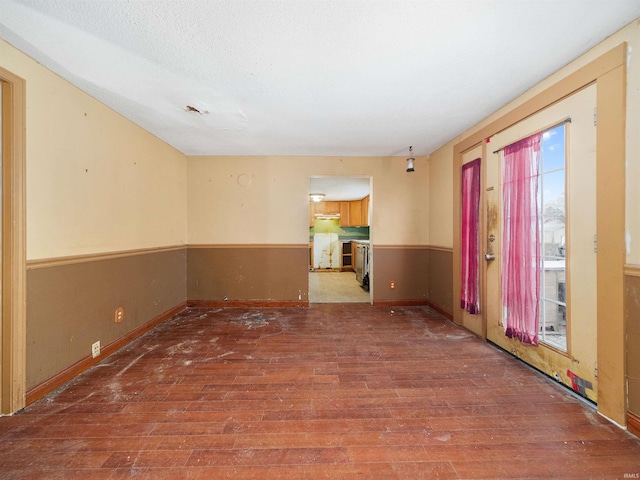 empty room featuring hardwood / wood-style flooring and a textured ceiling