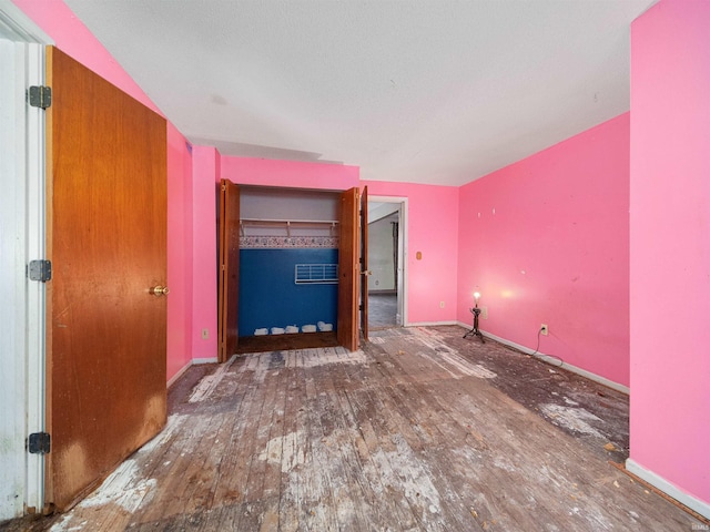 unfurnished bedroom featuring hardwood / wood-style floors and a closet