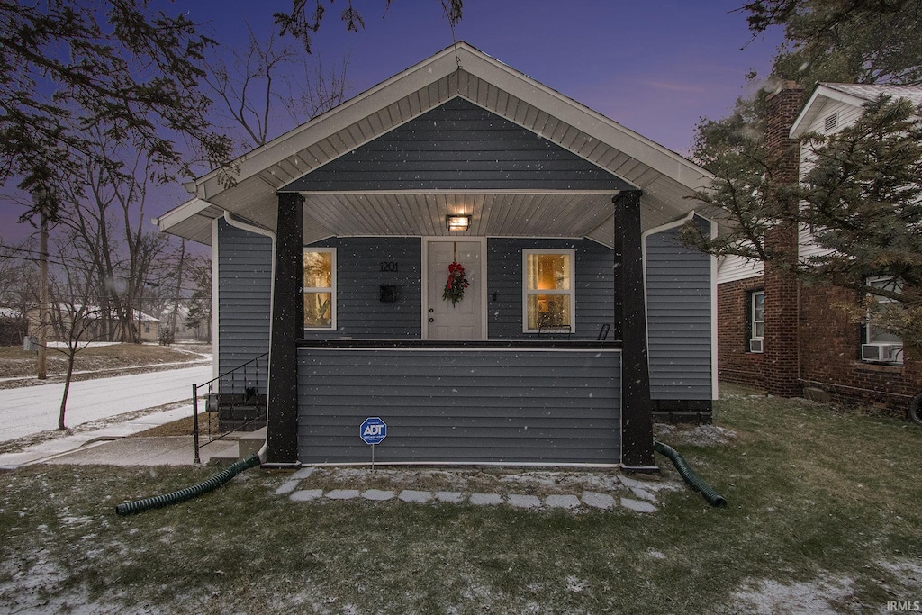 bungalow-style home featuring a yard and a porch