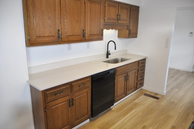 kitchen with sink, black dishwasher, and light hardwood / wood-style flooring