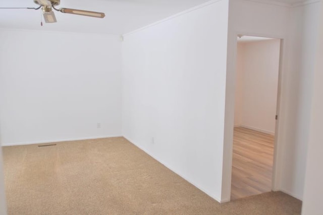 carpeted empty room featuring ceiling fan and crown molding