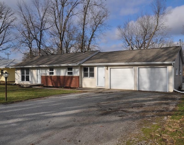 single story home featuring a garage and a yard