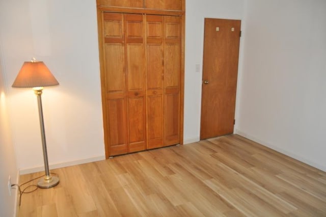 unfurnished bedroom featuring light hardwood / wood-style floors and a closet