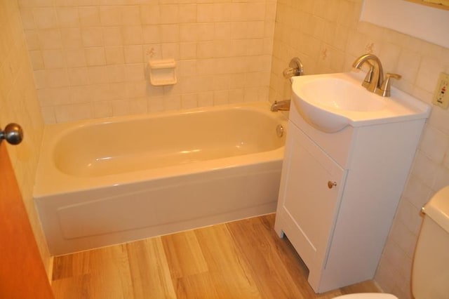 bathroom with backsplash, vanity, wood-type flooring, tile walls, and toilet