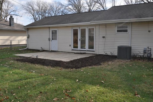 rear view of house featuring a patio area, a yard, and central air condition unit