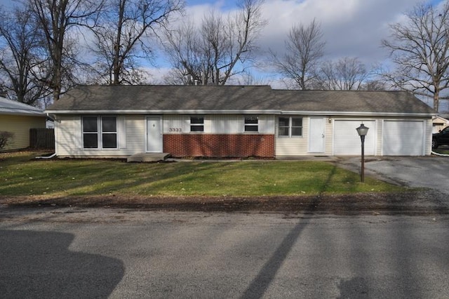 single story home with a garage and a front lawn