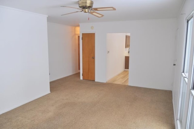 carpeted spare room featuring ceiling fan