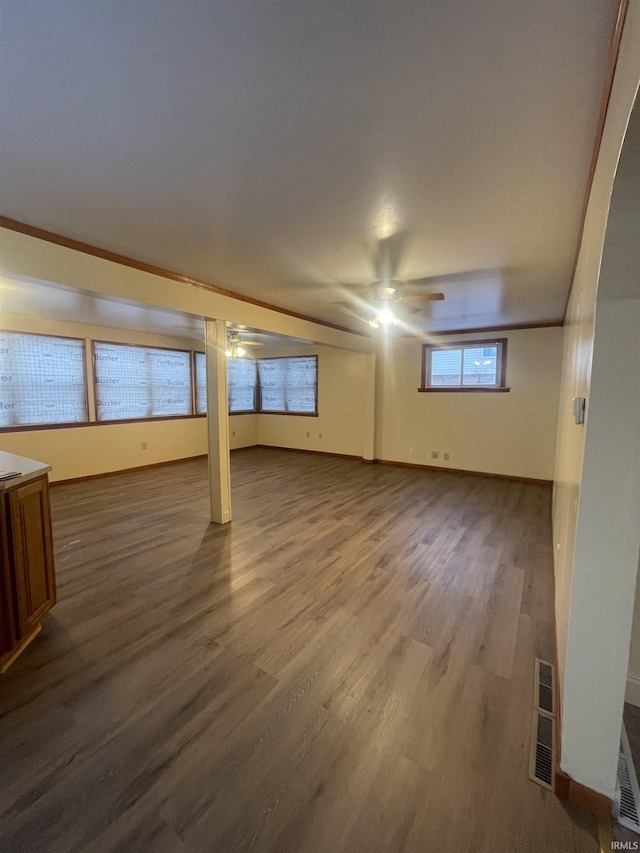 basement with dark hardwood / wood-style flooring and ornamental molding