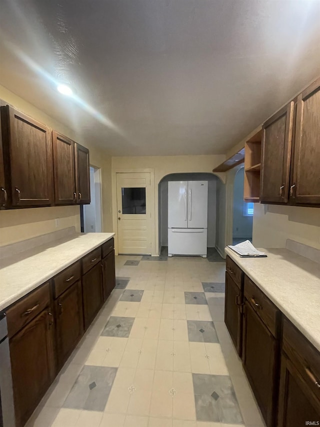 kitchen featuring dark brown cabinets and white appliances