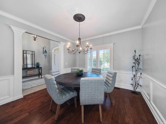 dining room with ornate columns, crown molding, dark hardwood / wood-style flooring, and an inviting chandelier