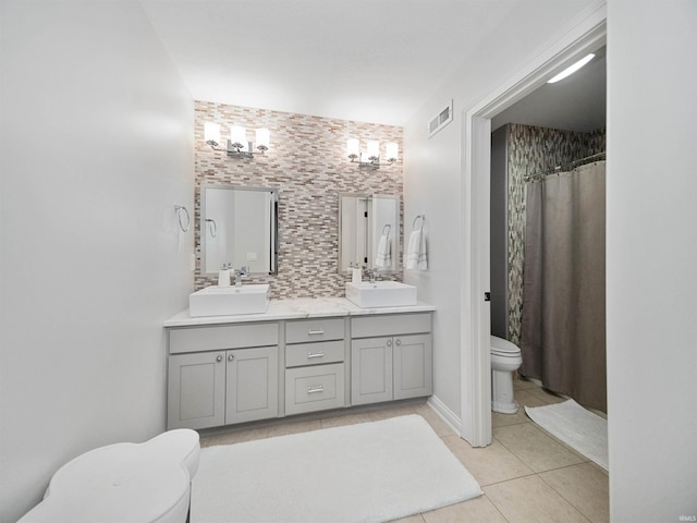 bathroom with tasteful backsplash, tile patterned flooring, toilet, vanity, and a shower with shower curtain