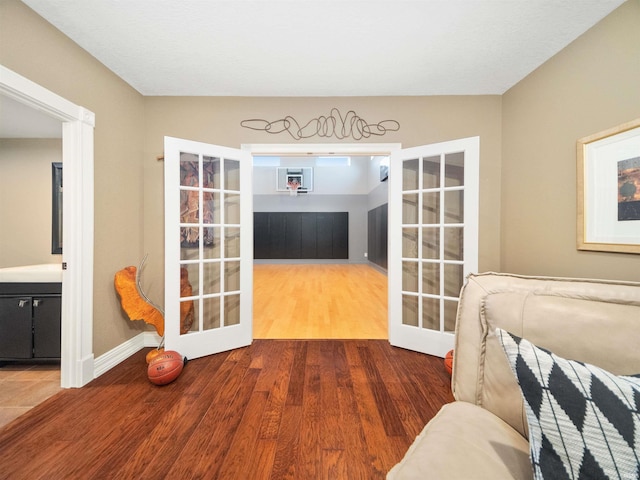 sitting room featuring wood-type flooring and french doors