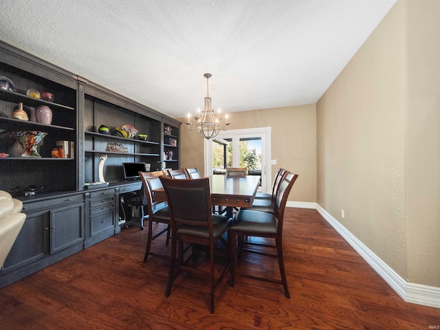 dining space with built in shelves, a textured ceiling, dark wood-type flooring, and a notable chandelier