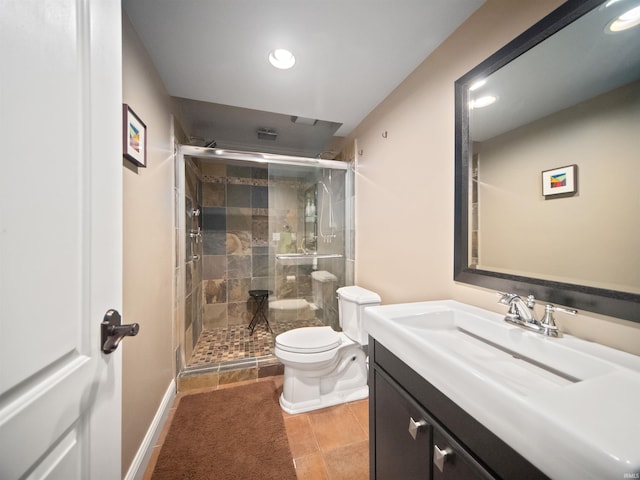 bathroom featuring tile patterned flooring, vanity, toilet, and a shower with door