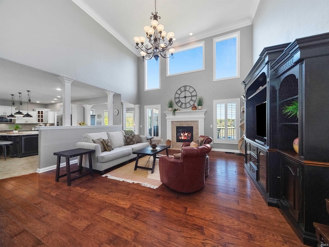 living room with crown molding, a high ceiling, dark hardwood / wood-style floors, and an inviting chandelier