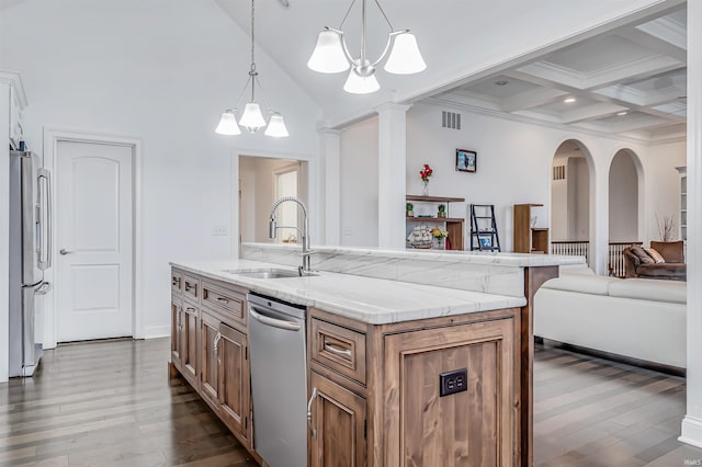 kitchen featuring stainless steel appliances, sink, pendant lighting, a center island with sink, and a notable chandelier