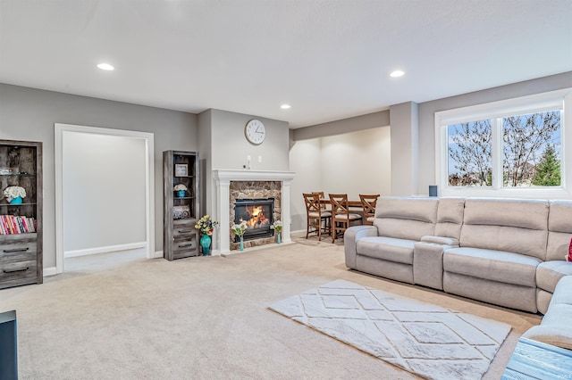 carpeted living room featuring a stone fireplace