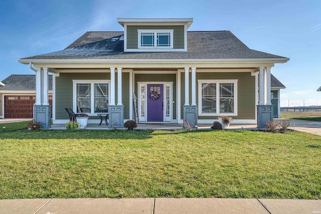 view of front of home featuring a garage, covered porch, and a front lawn