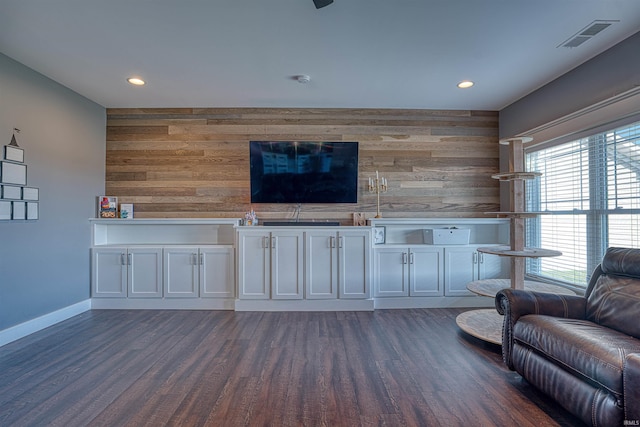 unfurnished living room featuring dark hardwood / wood-style floors and wood walls