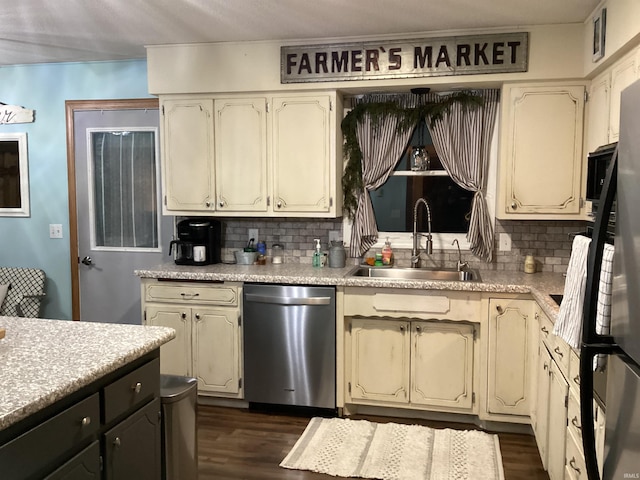 kitchen featuring dishwasher, cream cabinets, tasteful backsplash, and sink