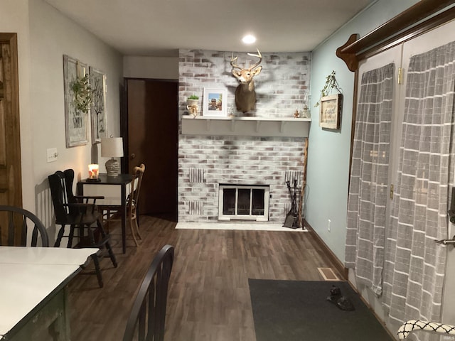 living room with wood-type flooring and a brick fireplace