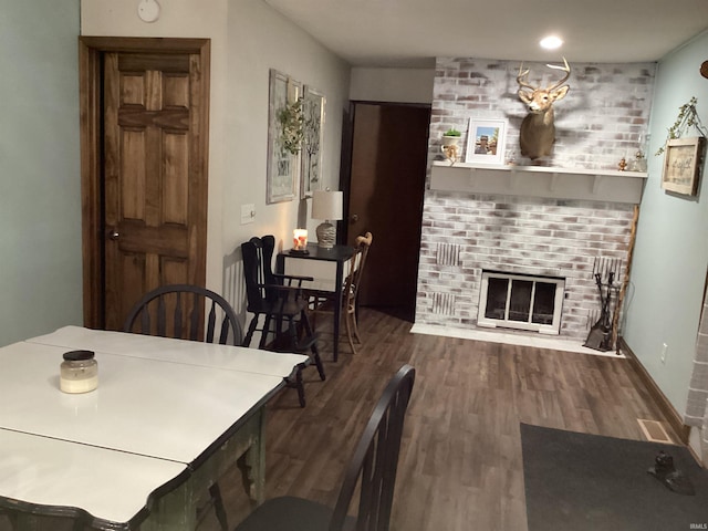 dining space with a fireplace and hardwood / wood-style flooring