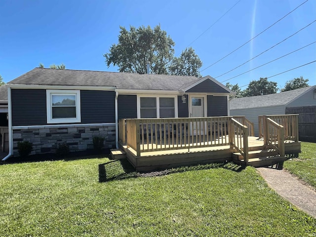 rear view of house with a wooden deck and a yard