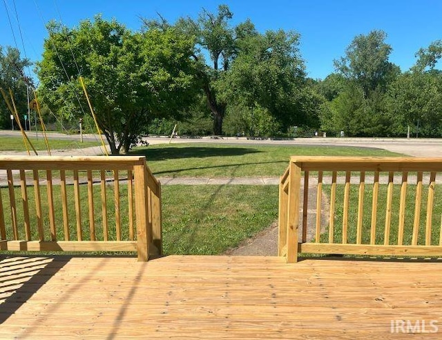 wooden terrace featuring a yard