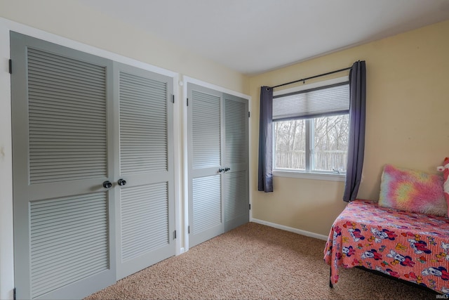 bedroom with carpet floors and two closets