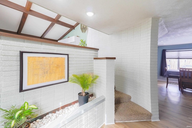 interior space with lofted ceiling with beams and hardwood / wood-style floors